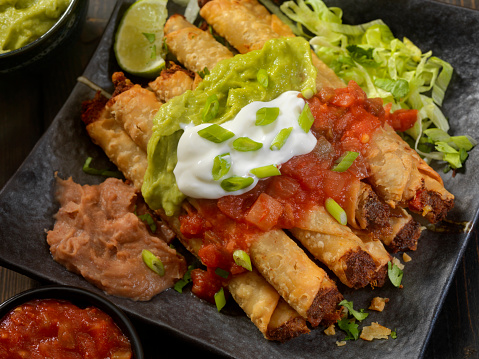 Beef Taquito Platter with Salsa, Sour Cream and Guacamole and re fried beans