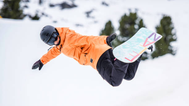 istock Female snowboarder in mid-air reaching for a grab 873627942