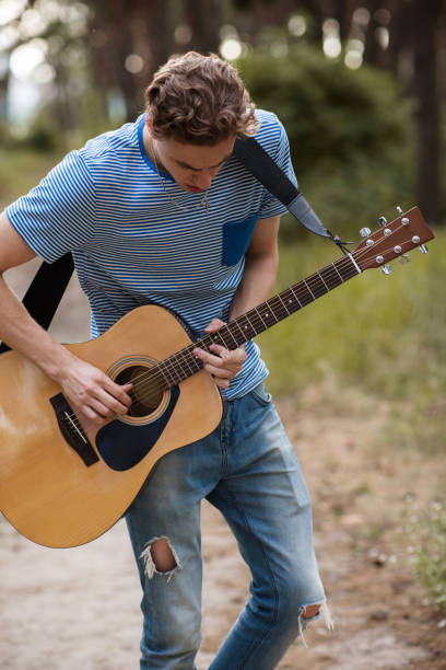 istock Talented guitarist playing forest hiking concept. 873635744