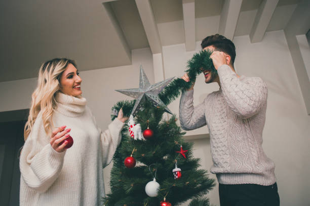 istock Boyfriend and girlfriend having a fun time beside Christmas tree 873635864