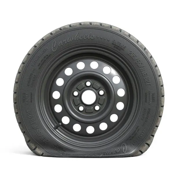 Photo of Punctured black car wheel isolated on white background.