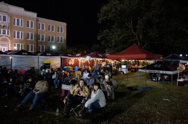 Watching the game from tailgating area Mississippi State, Mississippi, USA - November 11, 2017: Fans watching the game on the large screen from the tailgating area at the Mississippi State University versus The University of Alabama football game on the campus of Mississippi State. mississippi state university stock pictures, royalty-free photos & images