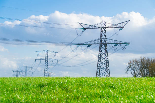 istock high voltage tower on grass field, against cloudy sky 873646622