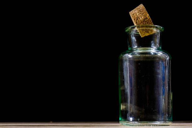 Empty bottles of milk on a wooden kitchen table. Bottle with a stopper. Black background