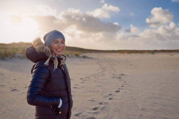 istock Trendy woman standing on a beach at sunset 873654746