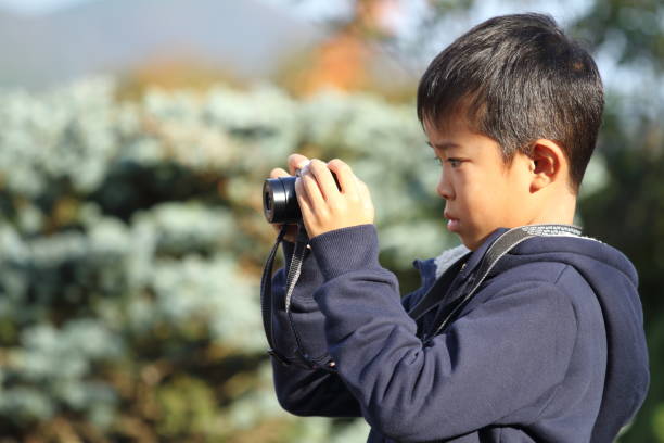 ragazzo giapponese che scatta una foto (seconda elementare) - fotocamera compatta foto e immagini stock