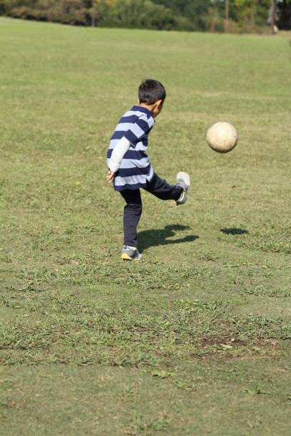 istock Japanese boy playing with soccer ball (second grade at elementary school) 873658144