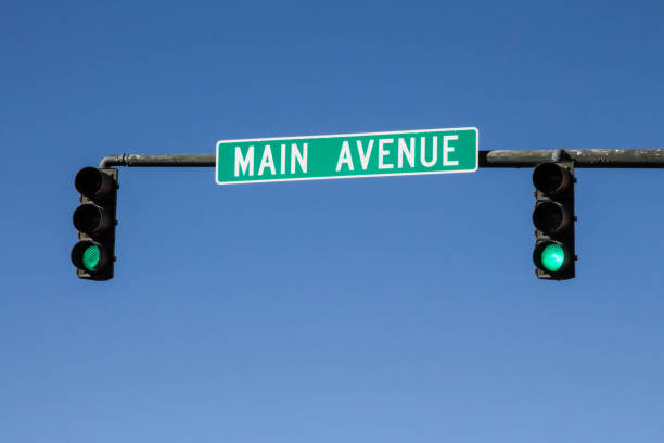 istock Main avenue sign with green traffic lights 873663678