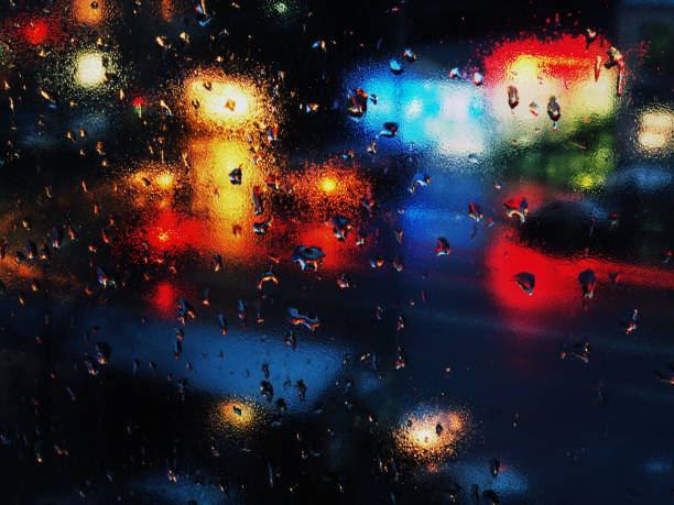 istock Abstract rain drops on window with night traffic lights. 873666744