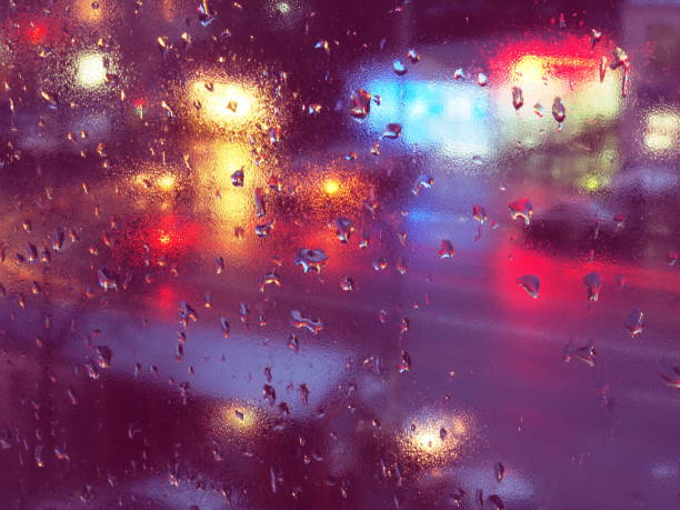 istock Abstract rain drops on window with night traffic lights. 873666794