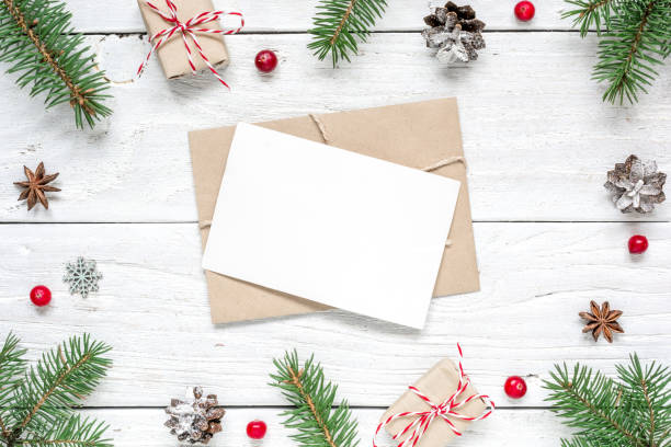 istock christmas composition with blank greeting card. fir tree branches, horse toy, gift boxes and cones frame 873673288