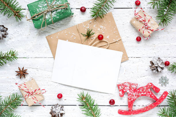 istock christmas composition with blank greeting card. fir tree branches, horse toy, gift boxes and cones frame 873673478