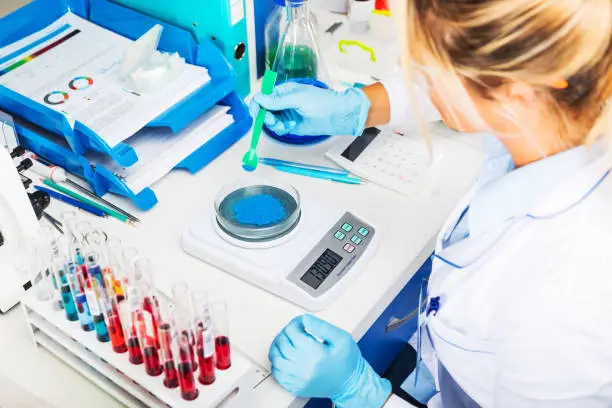 Photo of Scientist in gloves preparing chemical substances for the tests