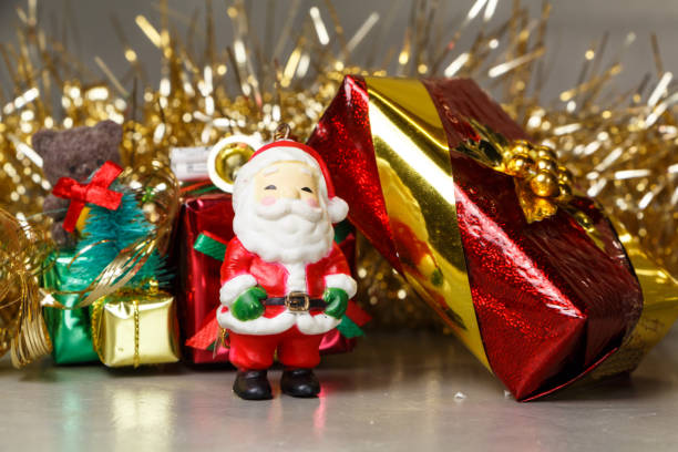 istock Santa Claus figurine with gift and golden tinsel 873699408