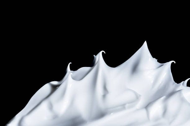 istock White cosmetic cream close-up macro texture background isolated on black 873702272