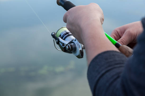 istock Fisherman hands holding a spinning reel 873705952