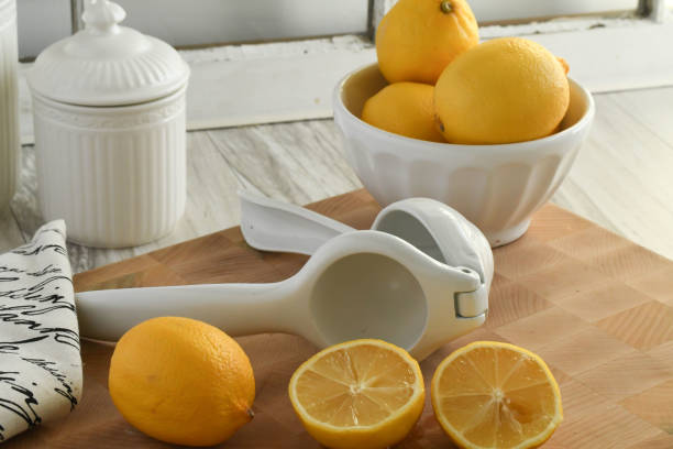 istock Lemons with white ceramic bowl, cannister and hand-held juicer 873711644