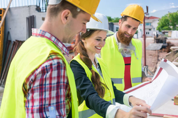 istock Confident female architect sharing ideas about the plan of a building under construction 873718660