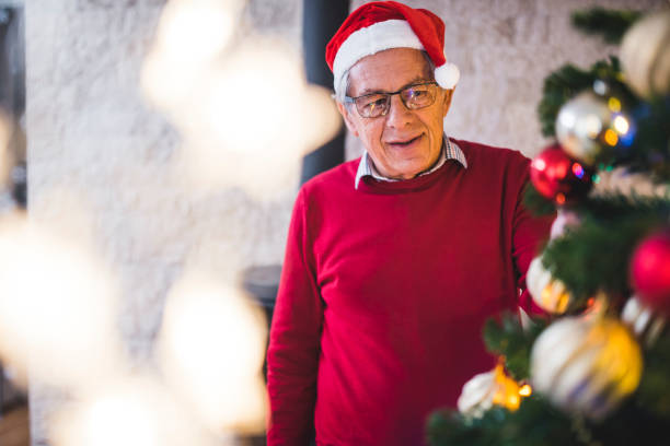 istock Senior man decorating the christmas tree 873719102