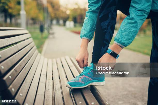 Woman Tying Up Her Shoe Lace Stock Photo - Download Image Now - Running, Sports Shoe, Tying