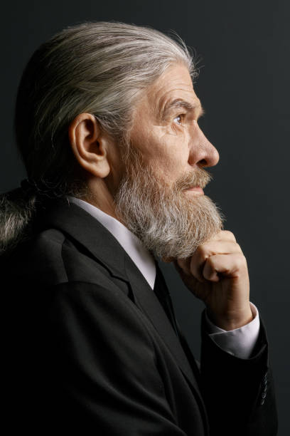 istock Pensive old male on dark background 873722550
