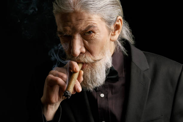 istock Stylish old man smoking cigar 873725374