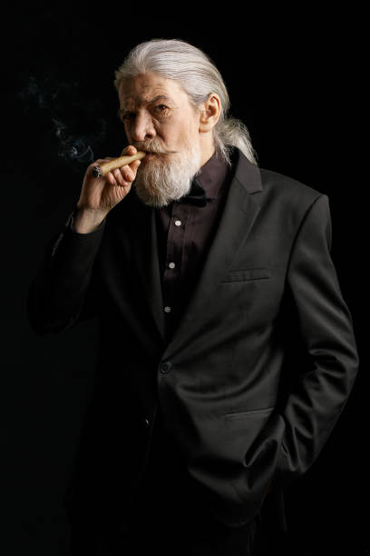 istock Aged wrinkled man standing against black background 873725450