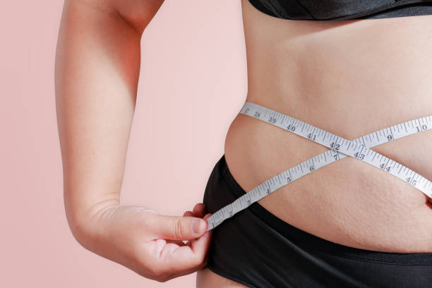 enfoque suave medir tu porcentaje de grasa corporal con la cinta para fondo de grasa u obesidad de medición - fat fotografías e imágenes de stock