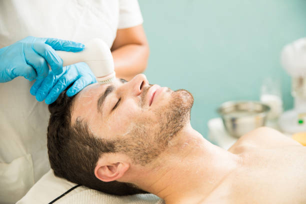 istock Young man getting a facial scrub 873736492