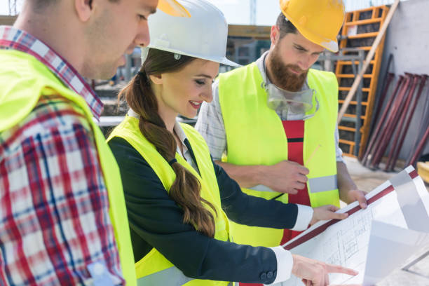 istock Confident female architect sharing ideas about the plan of a building under construction 873740208