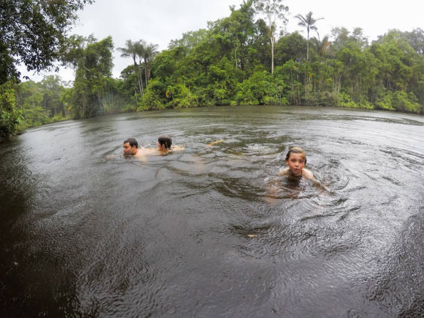 istock children and father swimming in the amazon while it rains 873746190