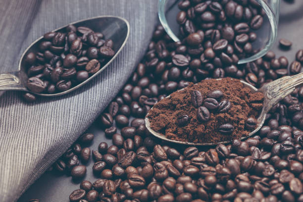 istock Steaming coffee in the morning. Scattered coffee seeds, old cup and spoon. 873754506
