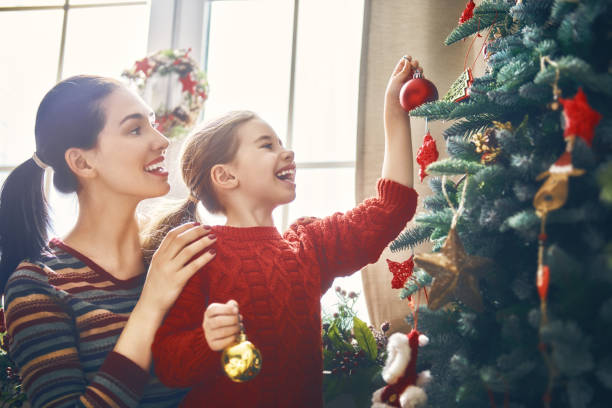 istock Mom and daughter decorate Christmas tree 873755426