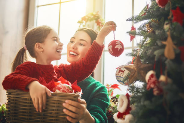 istock Mom and daughter decorate Christmas tree 873760934