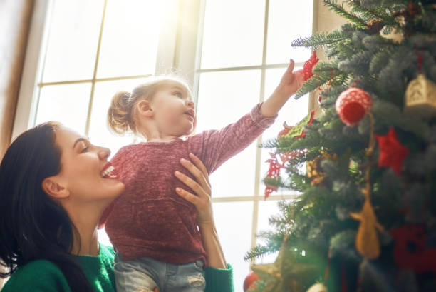 istock Mom and daughter decorate Christmas tree 873760948