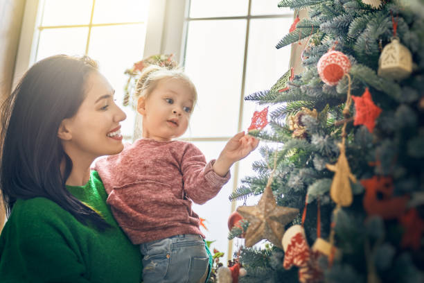 istock Mom and daughter decorate Christmas tree 873760988