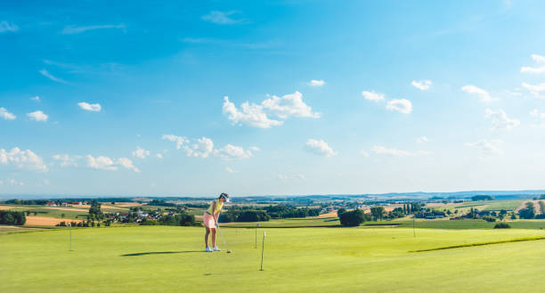 若い女性のゴルフ パッティ��ング グリーンの訓練区域の草の上を練習と判断 - golf green practicing sports training ストックフォトと画像
