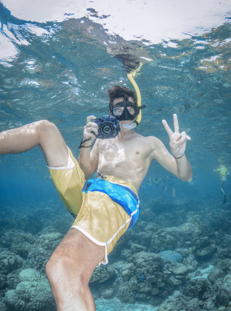 istock Man free diving with his Underwater Camera, Candid Gesture and Smile 873768356