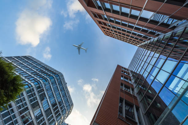 istock Skyscrapers with a flying airplane against blue sky 873769188