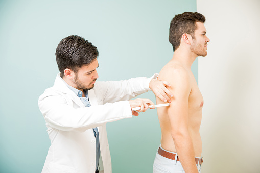 Profile view of a shirtless young man getting an evaluation at a nutritionist's office