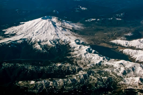 Aerial View of Mt St Helens Volcano with Snow Mt St Helens volcano with snowcapped landscape showing crater left from eruption taken from air. mount st helens stock pictures, royalty-free photos & images