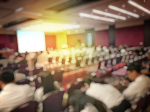 istock Abstract blurred image of people sitting in conference room for profession seminar with attendee, presenter and audience background, business & educaction concept, official new product launches 873776576