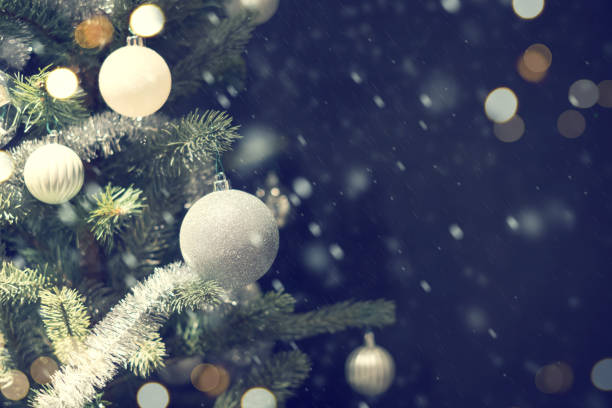 istock Closeup of silver bauble hanging from a decorated Christmas tree. 873783508
