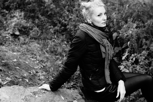young beautiful blond woman sadness alone in the autumn park.black and white style