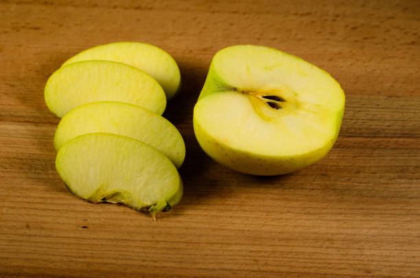 istock Sliced green apple on wooden table 873787268