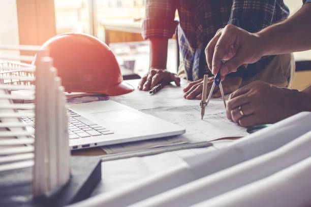 istock Concept architects, Two asian engineer pointing equipment architects On the desk with a blueprint in the office, Vintage, Sunset light.Selective Focus 873788336