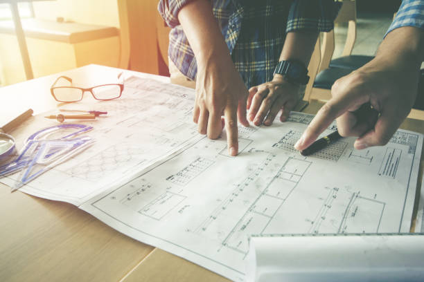 istock Concept architects, Two asian engineer pointing equipment architects On the desk with a blueprint in the office, Vintage, Sunset light.Selective Focus 873789388