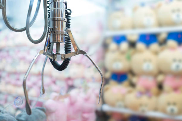 istock Claw game,A mechanical arm selecting a random soft toy in a vending machine. Selective focus at mechanical arm 873790624