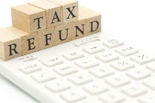 wood word TAX REFUND placed on a white calculator as background finance concept with copy space