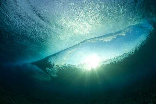 The view from under a breaking wave with the sun shining through